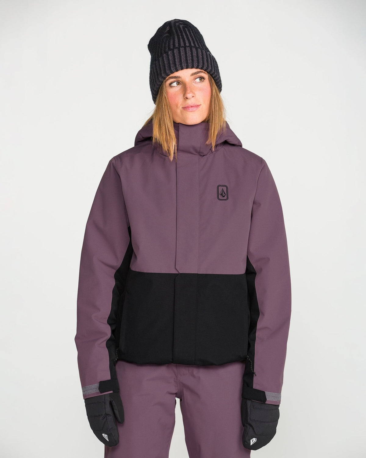 Volcom women's insulated snow jacket with two-tone colorblock design and hood, worn by model