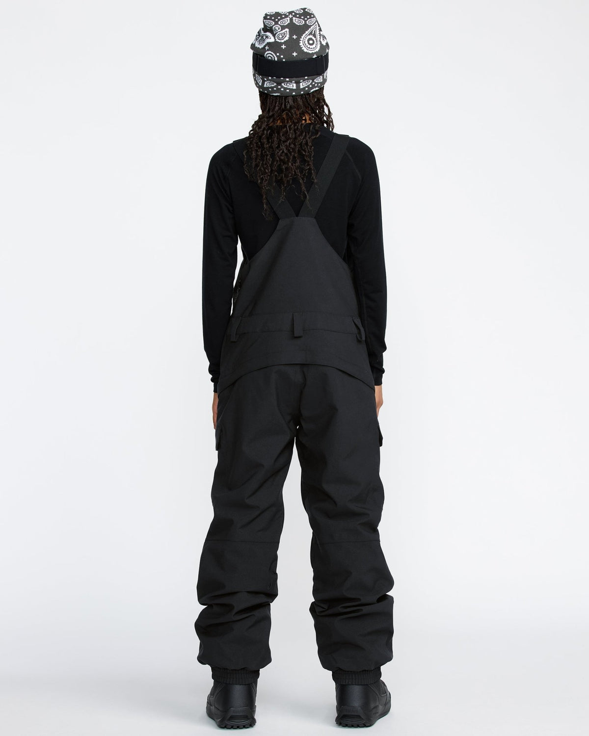 Women's snow bib pants with crossback straps, cargo pockets, and relaxed fit, shown from behind.