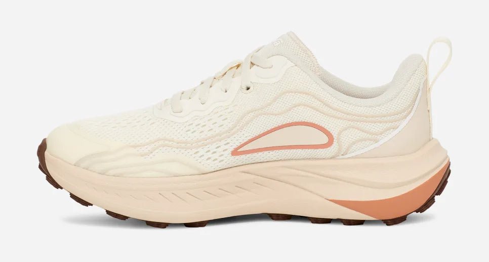 Women’s trail running and hiking shoe in birch and peach colors, side profile view.