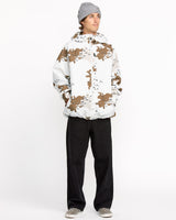 Men's hooded insulated jacket with camouflage pattern, worn with black pants and checkered sneakers