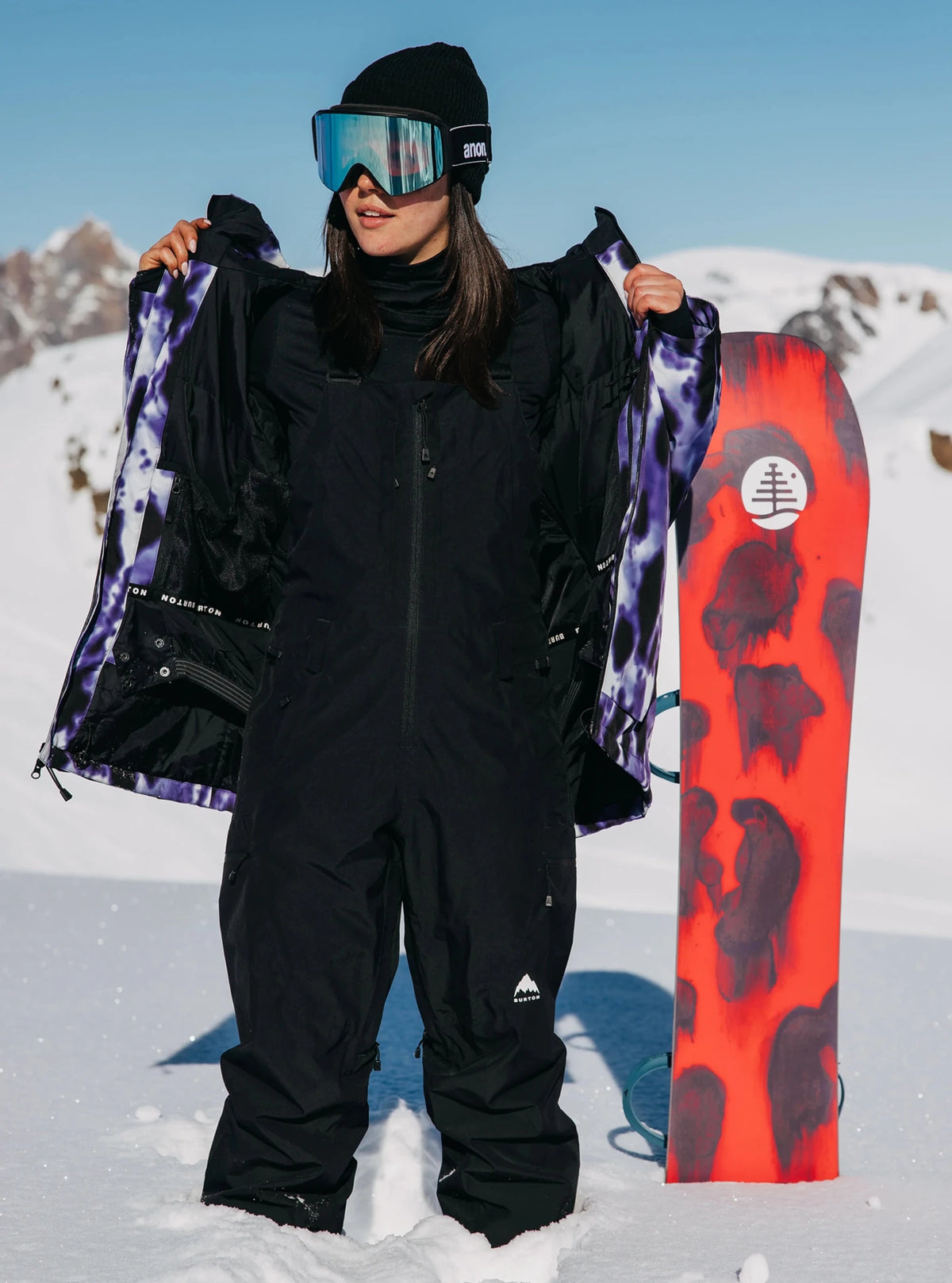 Burton women's Gore-Tex 2L bib pants with purple tie-dye interior lining shown open on model.