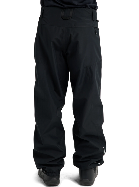 Burton women's relaxed fit snow pants shown from the back with ski boots