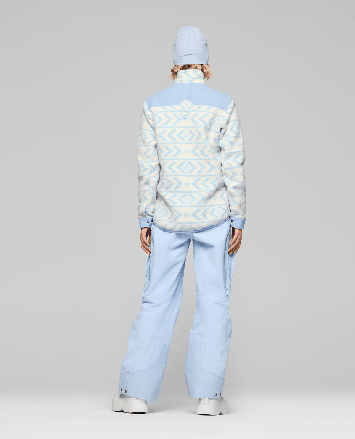 Women's Norrona fleece jacket with geometric pattern shown from back on model with matching pants