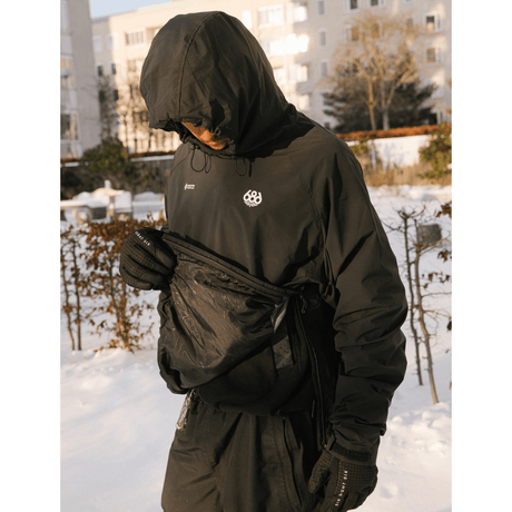 686 men's hooded pullover windbreaker with fanny pack worn outdoors in snow