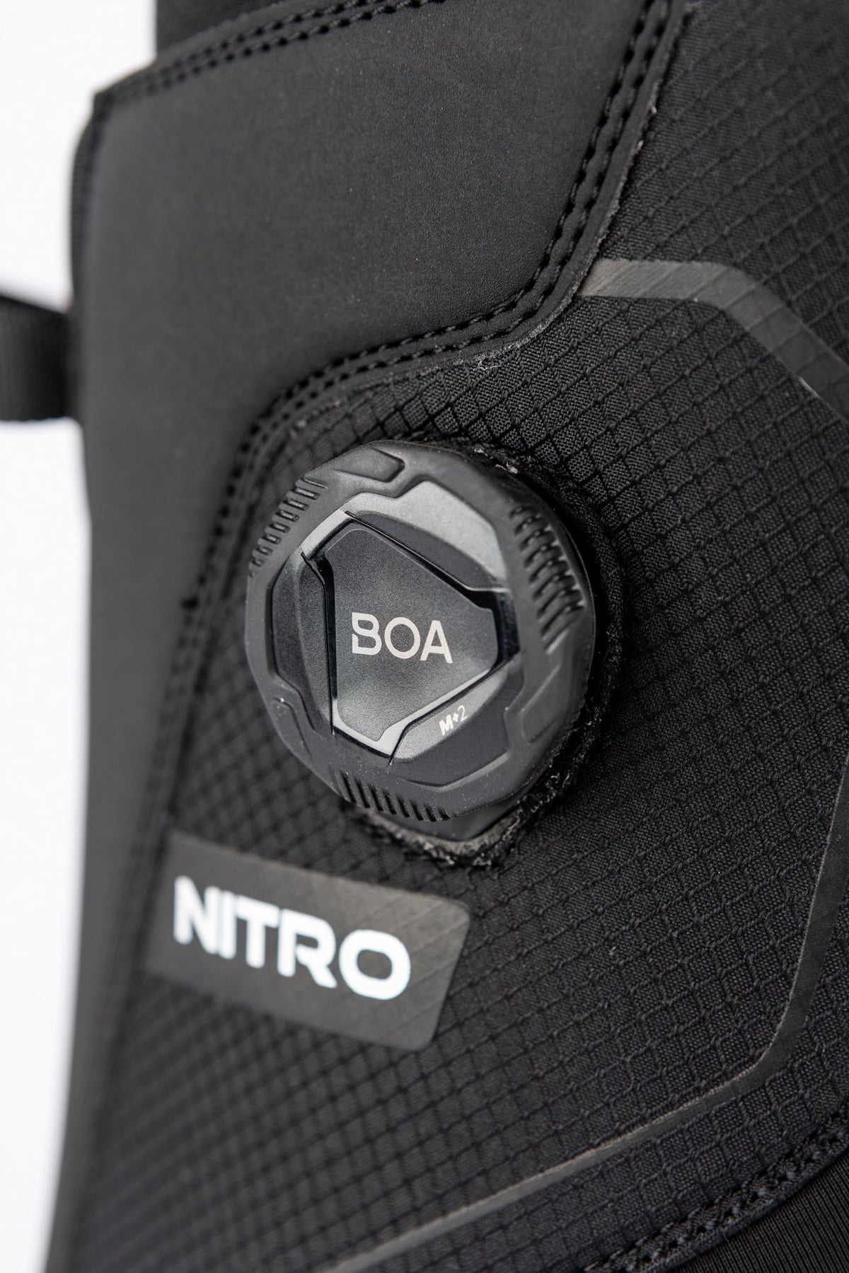 Close-up of Nitro snowboard boot featuring BOA M2 dial closure system on textured upper.