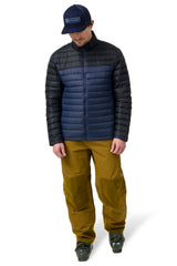 Men's technical ski pants with reinforced knees, worn with ski boots, full length view.