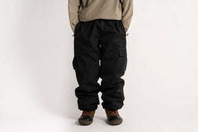Relaxed fit cargo pants with large side pockets and elastic waistband, styled with boots.