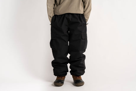Relaxed fit cargo pants with large side pockets and elastic waistband, styled with boots.