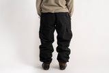 Autumn men's cargo snow pants with side pockets, worn with snowboard boots, rear view