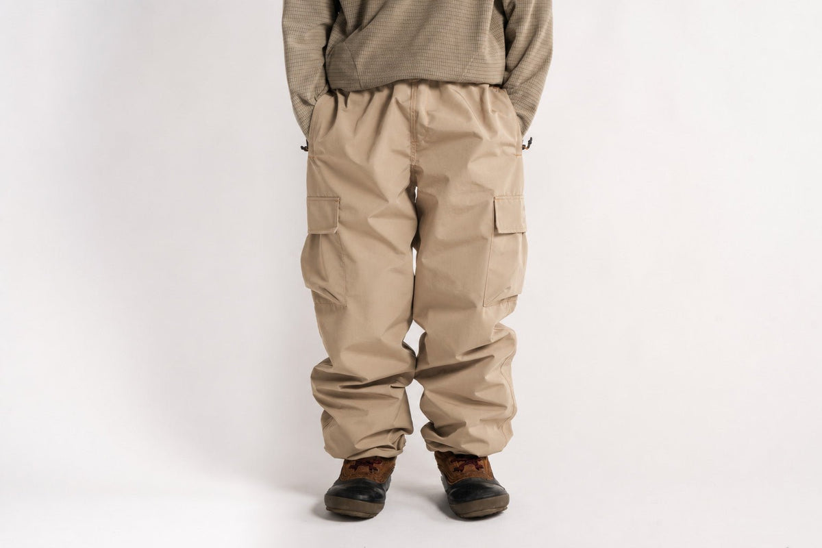 Baggy fit men's cargo pants with side pockets and elastic waistband, worn with boots.