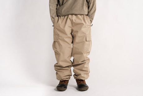 Baggy fit men's cargo pants with side pockets and elastic waistband, worn with boots.