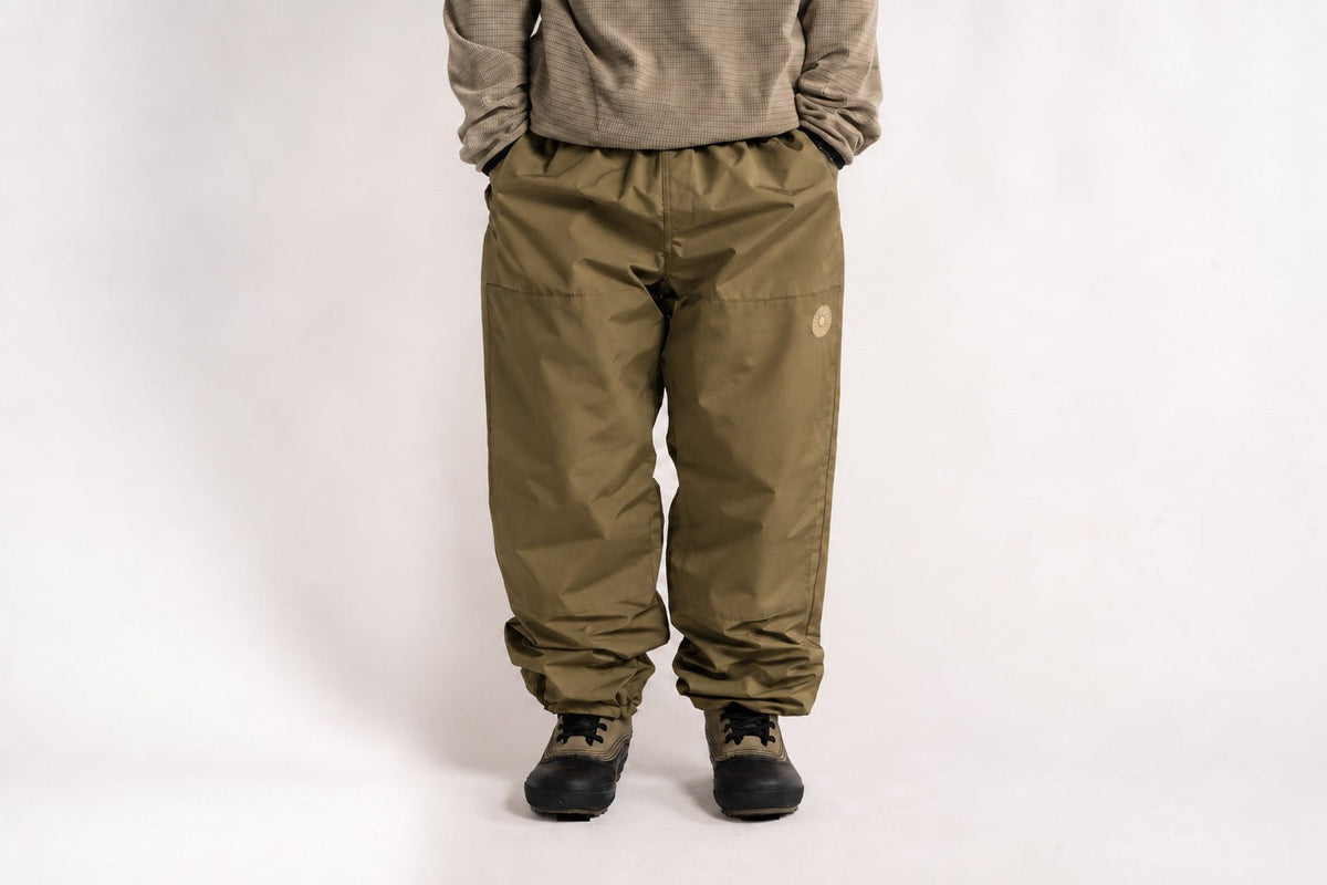 Relaxed fit men's snow pants with elastic waist, gathered ankles, and small logo patch