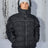 Men's insulated puffer jacket with hood, reflective piping, and front zip closure