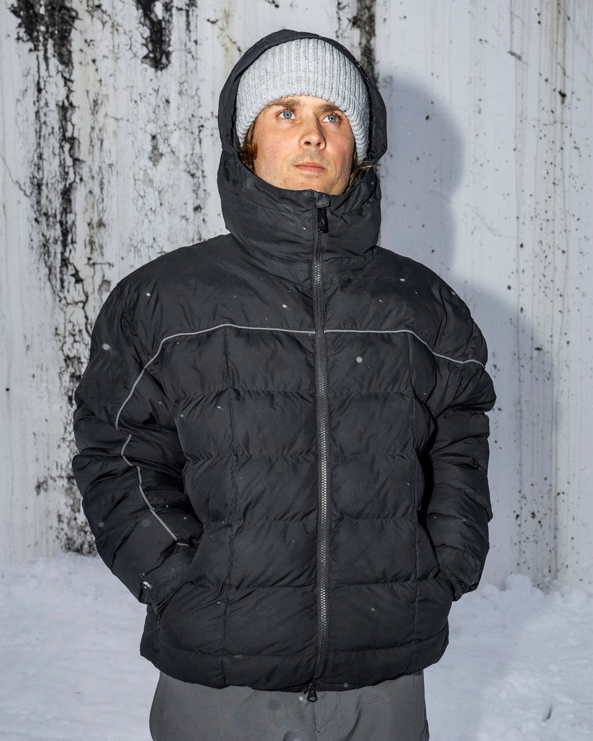 Men's insulated puffer jacket with hood, reflective piping, and front zip closure