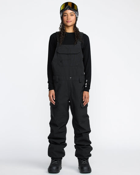 Women's snow bib overalls with cargo pockets, adjustable straps, and waterproof construction
