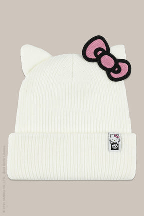 White ribbed knit beanie with cat ears, pink Hello Kitty bow patch, and branded label