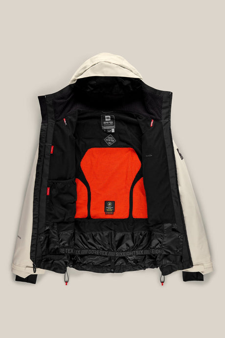 686 men's Gore-Tex ski jacket shown open revealing black and orange interior lining