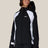 Women's fitted shell ski jacket with hood, gloves, and goggles on model