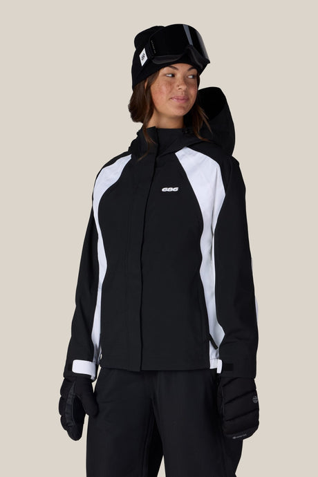 Women's fitted shell ski jacket with hood, gloves, and goggles on model