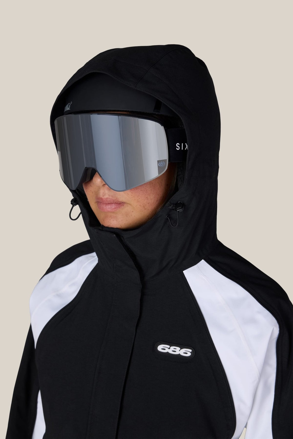Women's hooded shell ski jacket with goggle-compatible hood and front zip closure