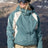 686 women's shell ski jacket with colorblock paneling worn by smiling model on snowy mountain