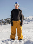 Men's insulated ski pants in a relaxed fit, worn on a snowy mountain slope