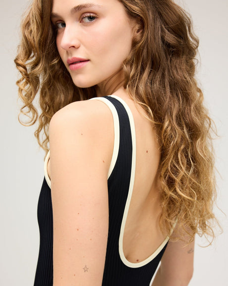 Black ribbed one-piece swimsuit with cream trim and low open back