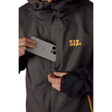 686 Six Crust men's hooded jacket with chest pocket shown storing a smartphone