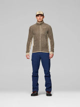 Men's full-zip fleece mid-layer jacket with contrast side panels, worn with navy pants