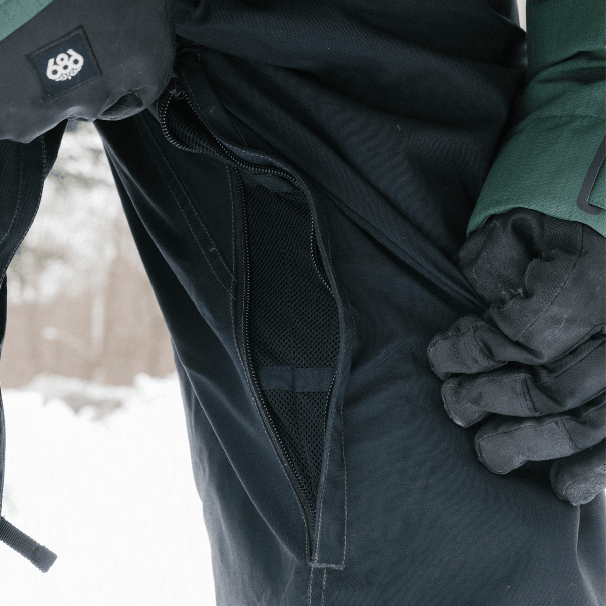 686 men's snow pants with open mesh ventilation zipper shown in detail close-up