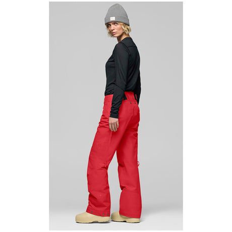 Women's technical ski pants with articulated knees and multiple pockets, modeled from side angle