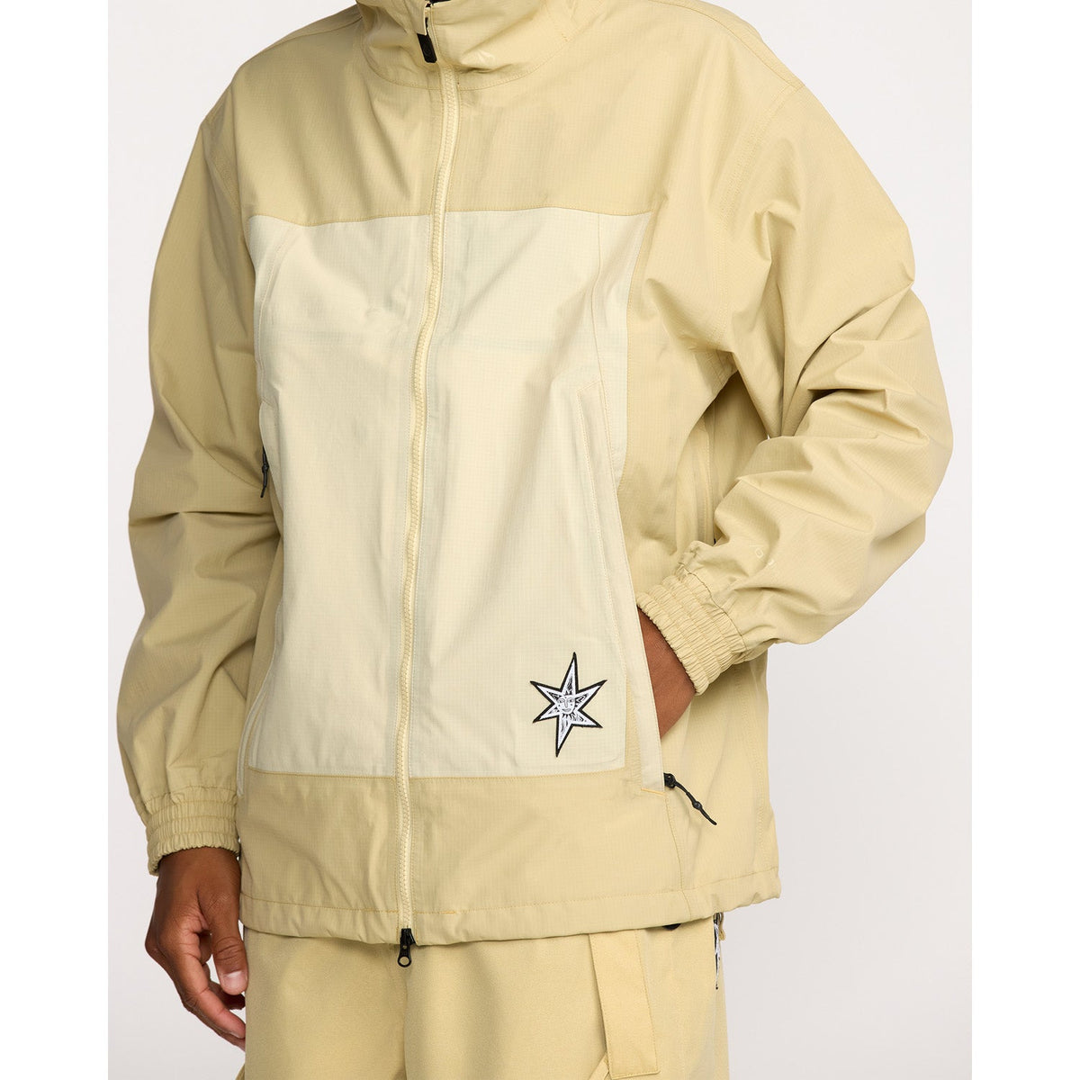 Men's zip-up technical jacket with two-tone paneling, mock neck, and star logo patch