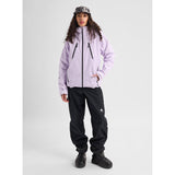 Women's insulated snowboard jacket with black zippers, worn with black snow pants and boots.