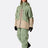 Women's Rab Bigline ski jacket with two-tone design, worn with matching green pants and ski boots.